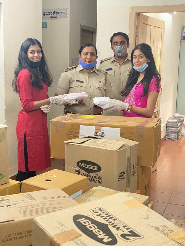 Nikita and Ria at the Koramangala police station with the kits that have to be distributed.
 (Source: The News Minute)