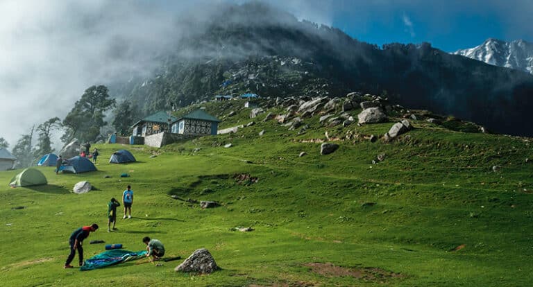5 Amazing Treks In Himachal Pradesh To Try In 2026: Full Guide Trekkers on the Triund meadow with the Dhauladhar range behind, Himachal Pradesh