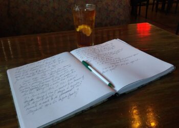 An open notebook with handwritten notes and a pen