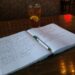 An open notebook with handwritten notes and a pen