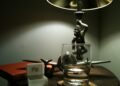 A bedside lamp and nightstand in a dark bedroom