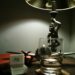 A bedside lamp and nightstand in a dark bedroom