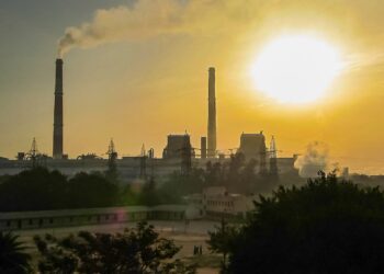 Air Pollution and Health: How to Stay Safe on High AQI Days Hazy sunrise over Delhi with smoke from a power plant clouding the sky