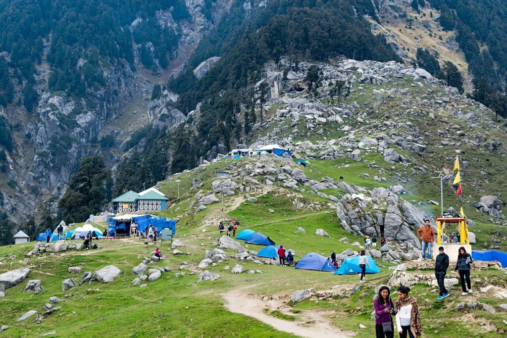 5 Amazing Treks In Himachal Pradesh To Try In 2026: Full Guide Trekkers on the Triund meadow with the Dhauladhar range behind, Himachal Pradesh