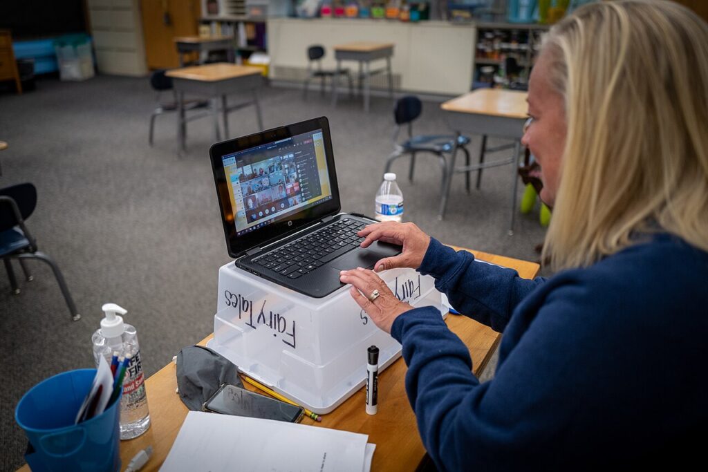 A teacher using a laptop to prepare lessons and take online classes