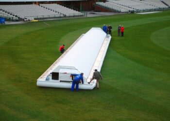DLS Method in Cricket Explained: How Rain-Hit Targets Are Set Hover cover protecting the pitch at Old Trafford cricket ground during rain
