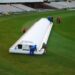 DLS Method in Cricket Explained: How Rain-Hit Targets Are Set Hover cover protecting the pitch at Old Trafford cricket ground during rain