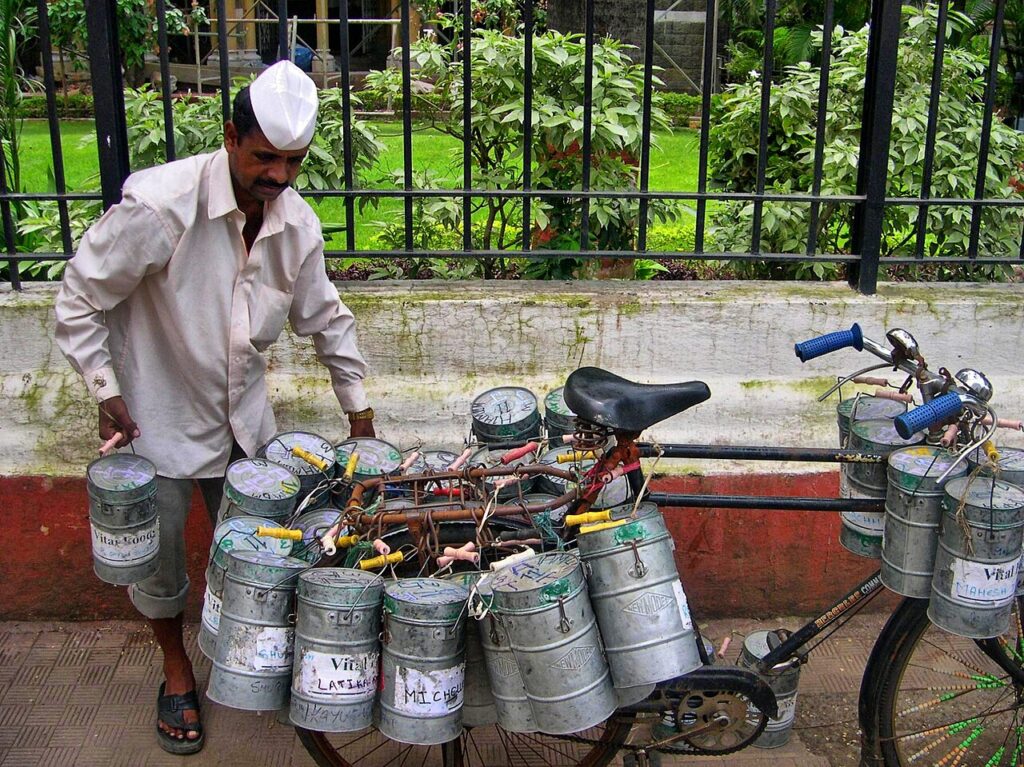 Quick Commerce in India Explained: How 10-Minute Delivery Works A Mumbai dabbawala carrying lunch boxes for delivery