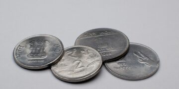 Coins and a savings jar representing a choice between recurring deposit and SIP