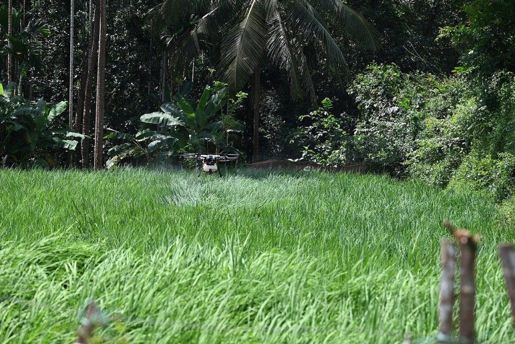 10 Technological Innovations Transforming Indian Agriculture Agricultural drone spraying a crop field, one of the technologies transforming Indian agriculture